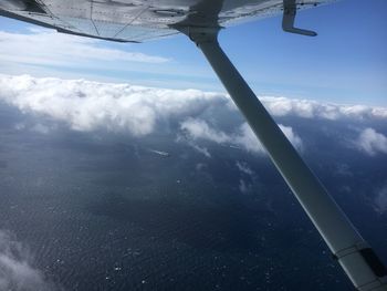 Airplane flying over sea against sky