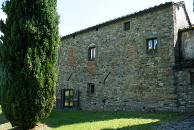 Exterior of old house by building against sky