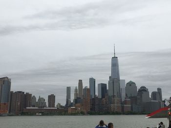 View of buildings in city against cloudy sky