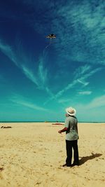 Full length of person standing on beach against sky