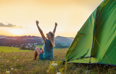 Rear view of woman sitting on tent