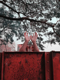 Low section of man hand against the tree