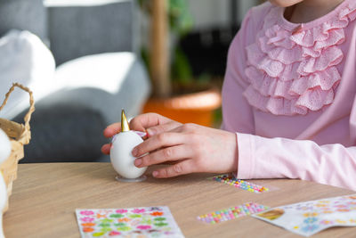 Midsection of woman holding sparkler at table