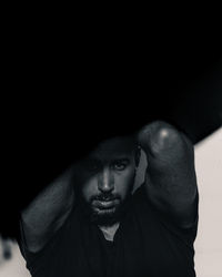 Portrait of young man against black background