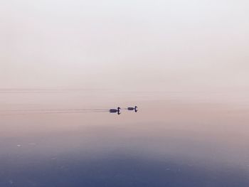 Lone boat in calm lake against clear sky