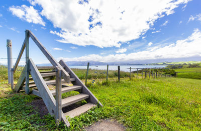 Wooden posts on beach against sky