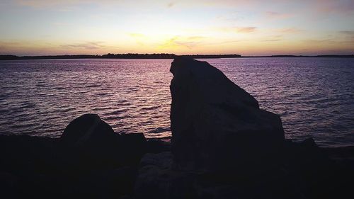 Close-up of sea against dramatic sky during sunset