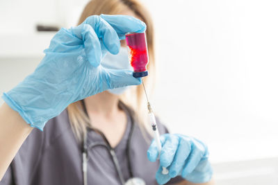 Midsection of doctor holding dentures