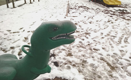 High angle view of dragon sculpture on snow covered field