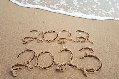 High angle view of text on sand