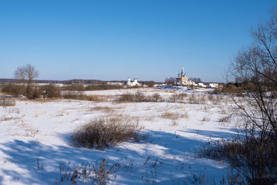 Scenic view of snow covered field against clear sky