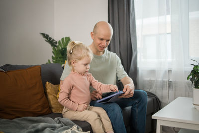 Side view of boy using digital tablet at home