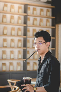 Portrait of young man drinking coffee at restaurant