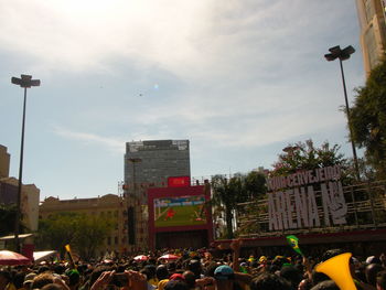 People on street in city against sky