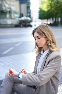 Young businesswoman using mobile phone in city