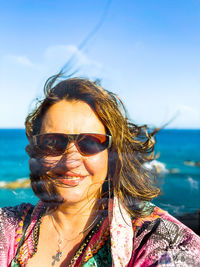 Portrait of woman wearing sunglasses against sky