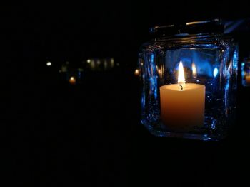 Close-up of illuminated candle in darkroom