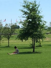 Woman using phone while sitting on grass
