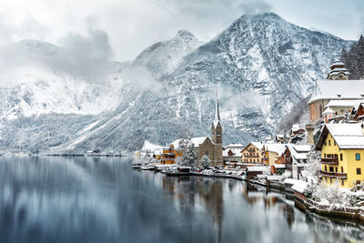 Panoramic view of frozen lake by snowcapped mountains against sky