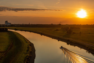 Scenic view of agricultural field against sky during sunset