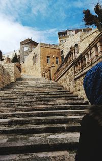 Low angle view of steps amidst buildings against sky