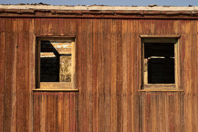 Windows in the side wood wall of abandoned railroad caboose in ghost town of rhyolite, nevada, usa