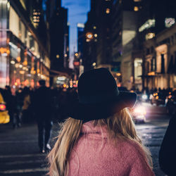 Woman standing in illuminated city at night