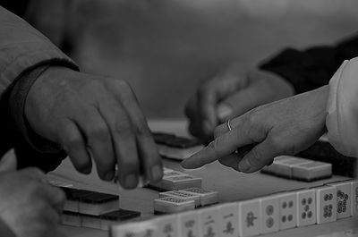 Cropped hands playing with gambling chips on table