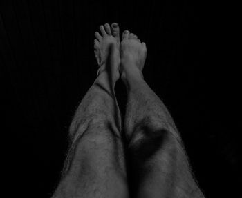 Low section of woman legs against black background