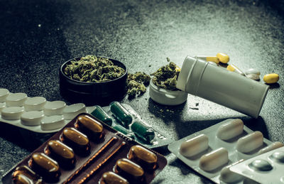 High angle view of marijuana with medicines on table