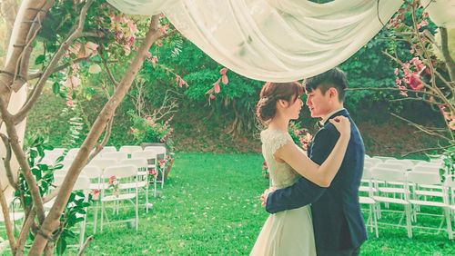 Young couple standing against plants