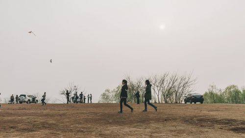 People on field against clear sky