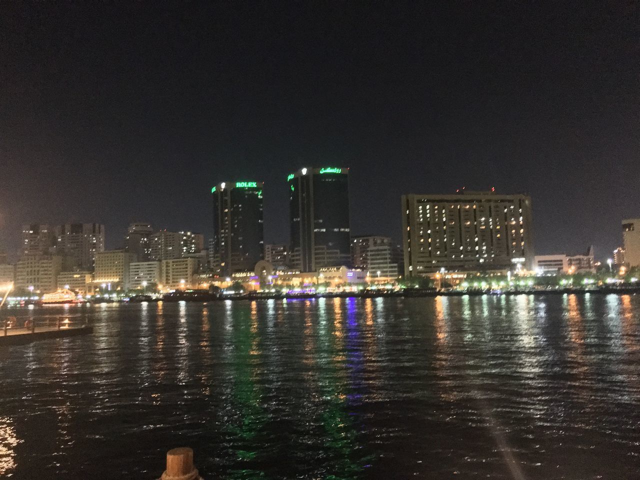 ILLUMINATED BUILDINGS BY RIVER AT NIGHT