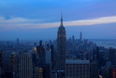 Modern buildings in city against cloudy sky