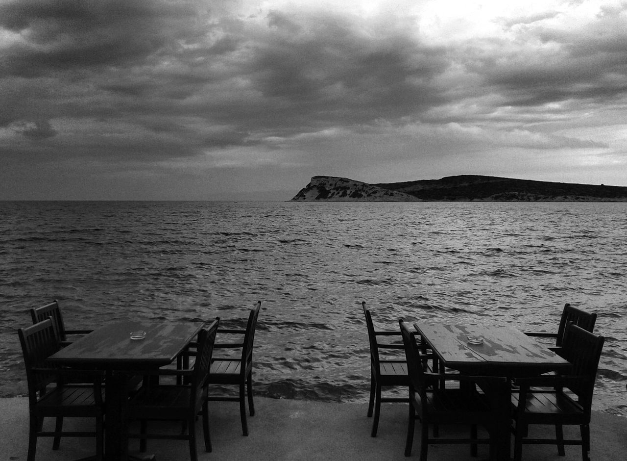 sea, water, sky, tranquil scene, horizon over water, tranquility, scenics, beach, chair, empty, beauty in nature, absence, nature, cloud - sky, bench, relaxation, shore, idyllic, sand, vacations