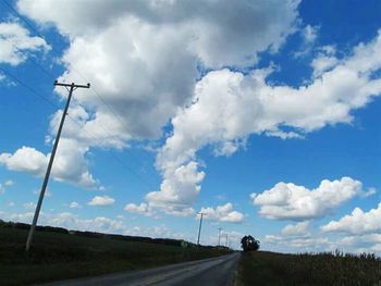 Country road against cloudy sky