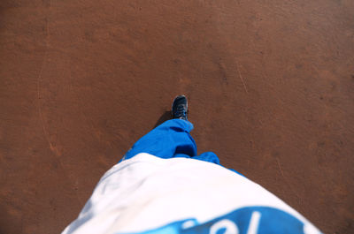 Low section of man standing on sand