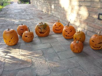 View of pumpkins against stone wall during halloween