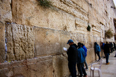 Rear view of two people in front of old building