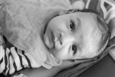 High angle portrait of cute baby lying on bed