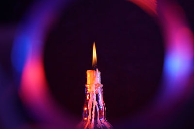 Close-up of illuminated candles in darkroom