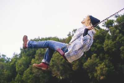 Low angle view of woman sitting on swing