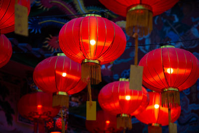 Low angle view of illuminated lanterns hanging at night