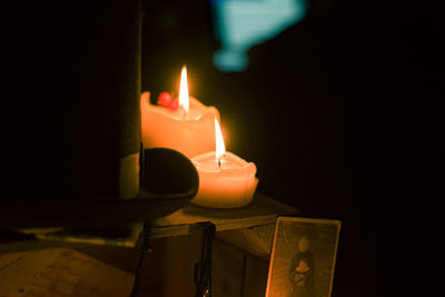 Close-up of lit candles in darkroom