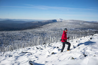 Man on snowcapped mountain against sky