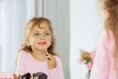 Portrait of young woman blowing bubbles at home