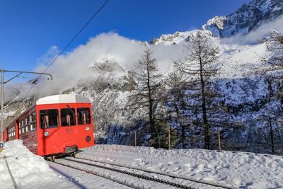 Tram on snow covered against sky
