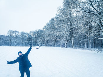 Man standing on snow covered field against sky