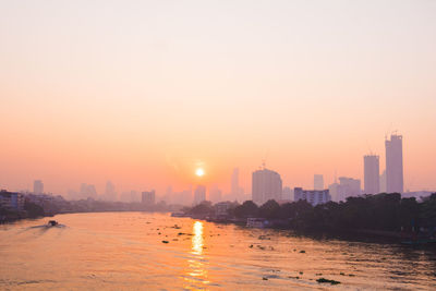 City buildings against clear sky during sunset
