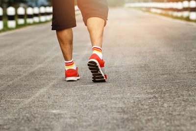 Low section of man walking on road